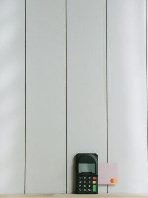 A sleek payment terminal with buttons against a white wooden background, ideal for finance concept.